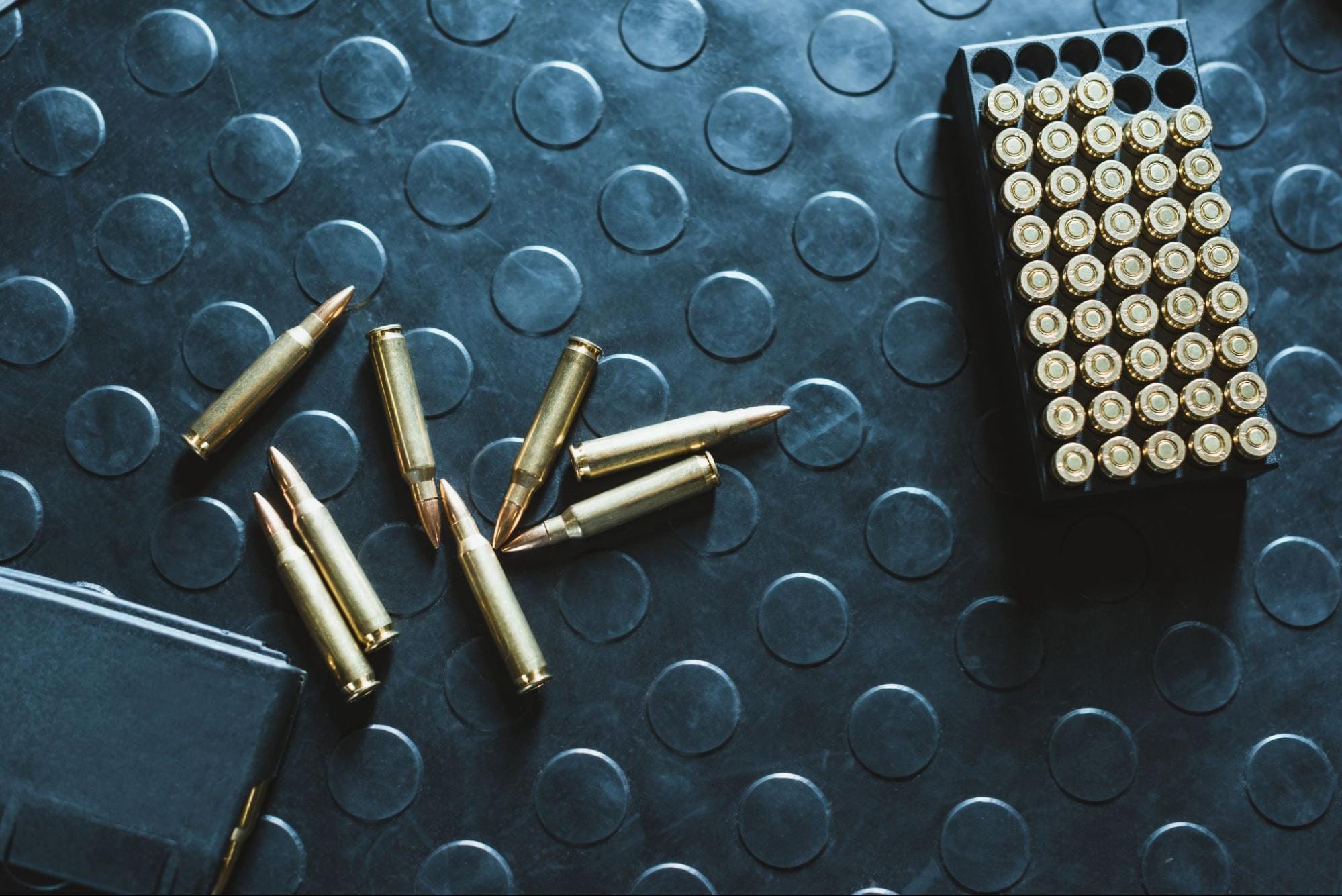 Bullets on textured black surface with case.