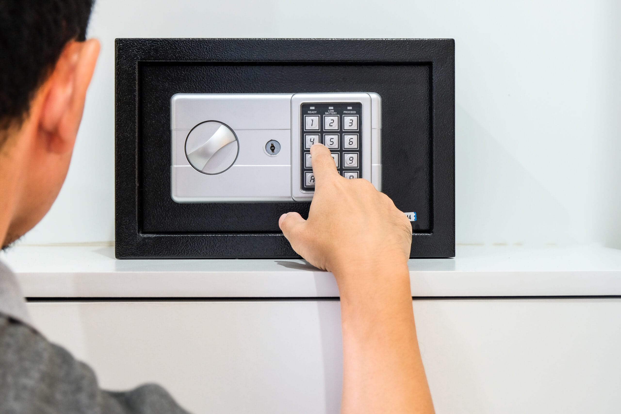 Person entering code on small safe keypad