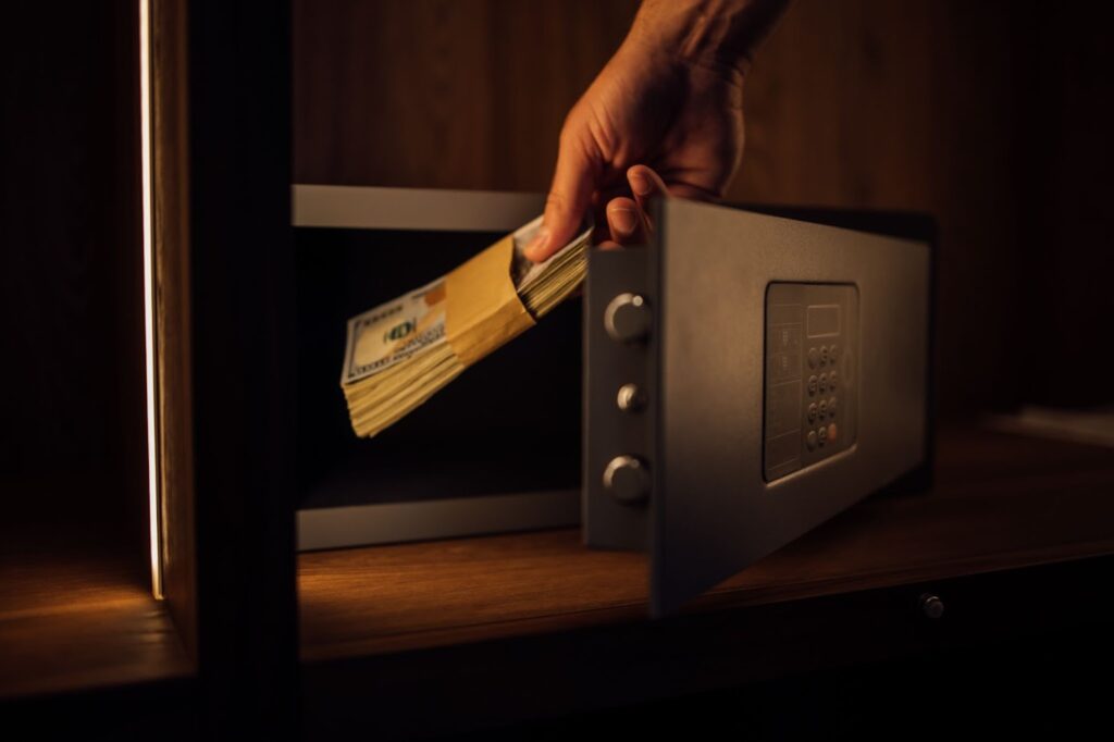 Hand placing money in safe